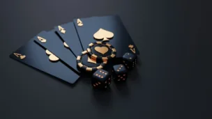 An image of poker chips, poker hand and dice on a matte black table with gold inlays