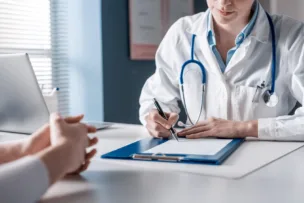 A doctor or nurse filling out a clipboard with patient